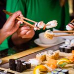 Young people eating sushi in Asian restaurant